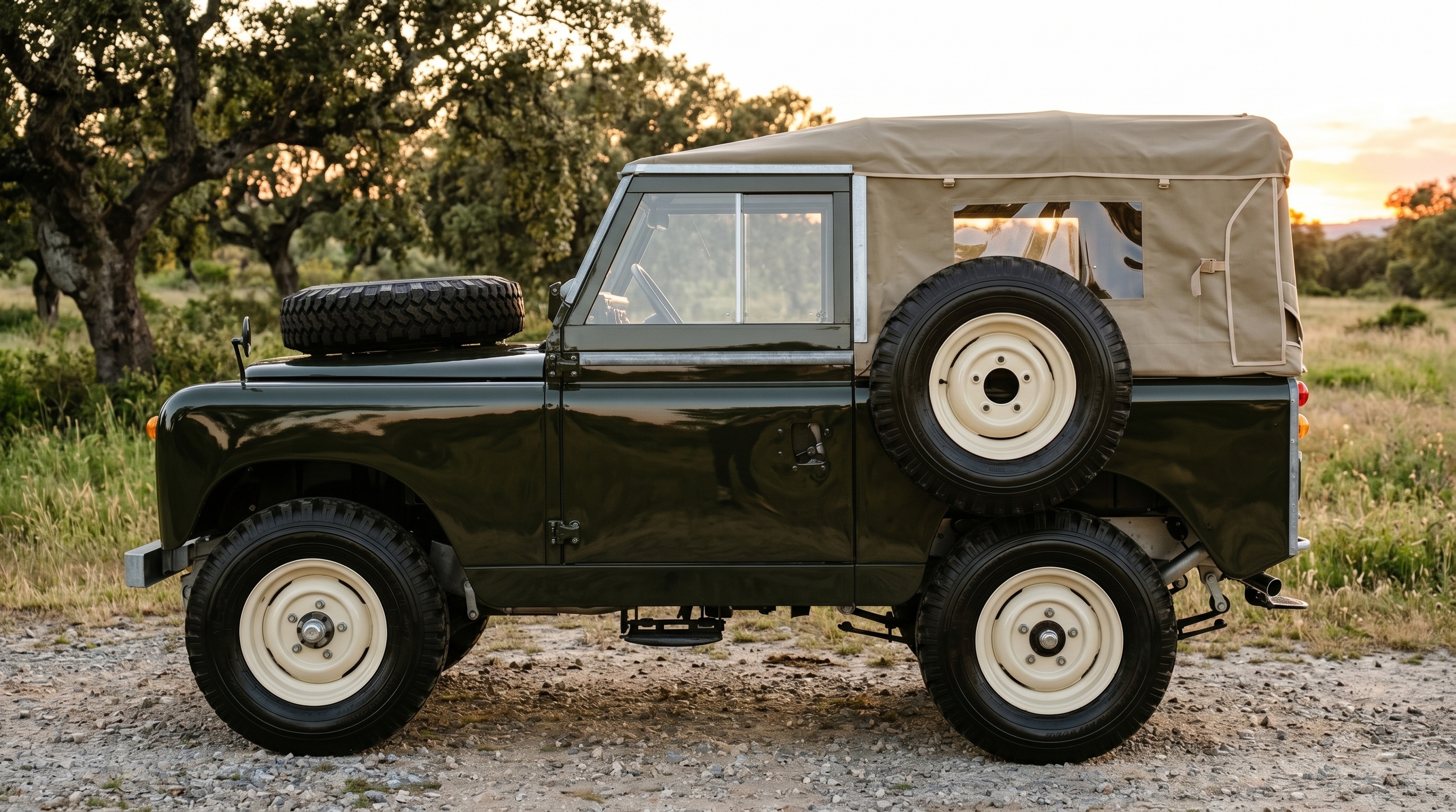 A 1968 Land Rover Series IIA 88-inch in Deep Bronze Green parked on a gravel driveway at golden hour